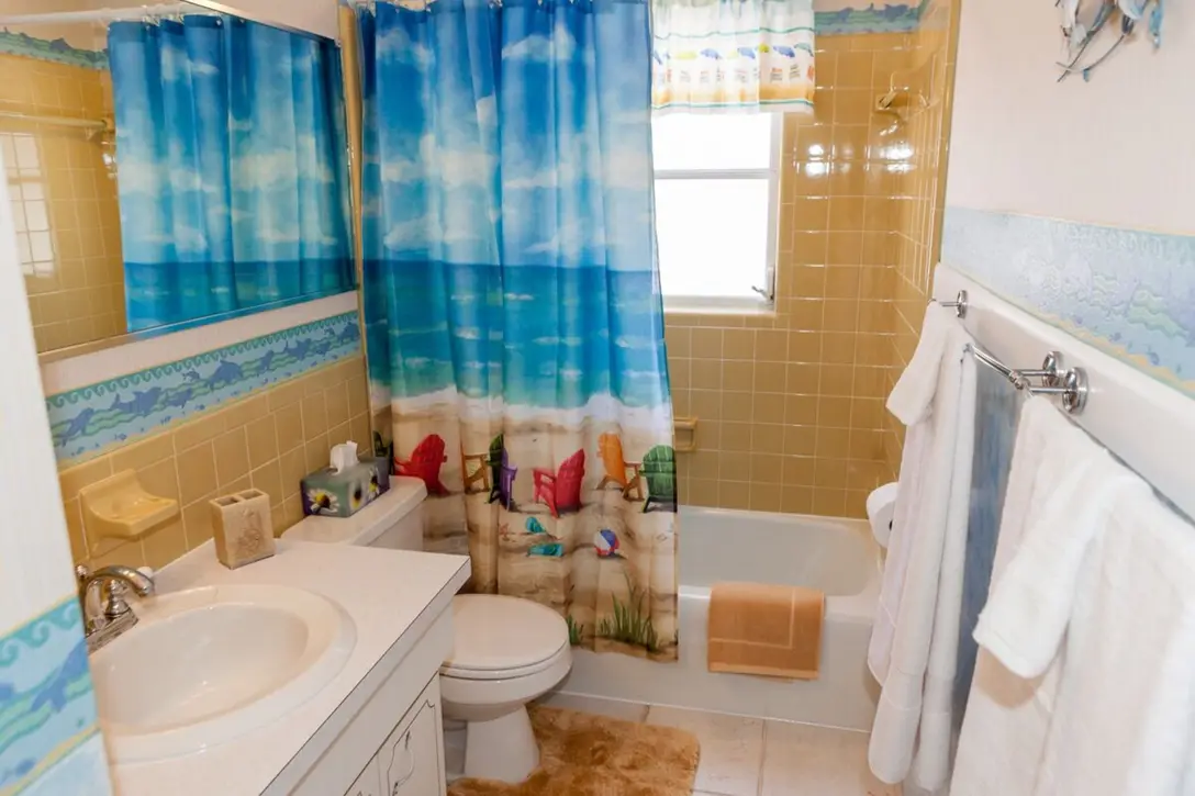 Bathroom with tub, shower, and beach-print curtain, Happy Turtle A