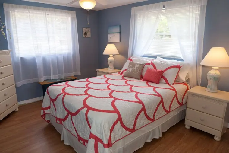 Queen bedroom with coral scalloped quilt and twin lamps, Happy Turtle A