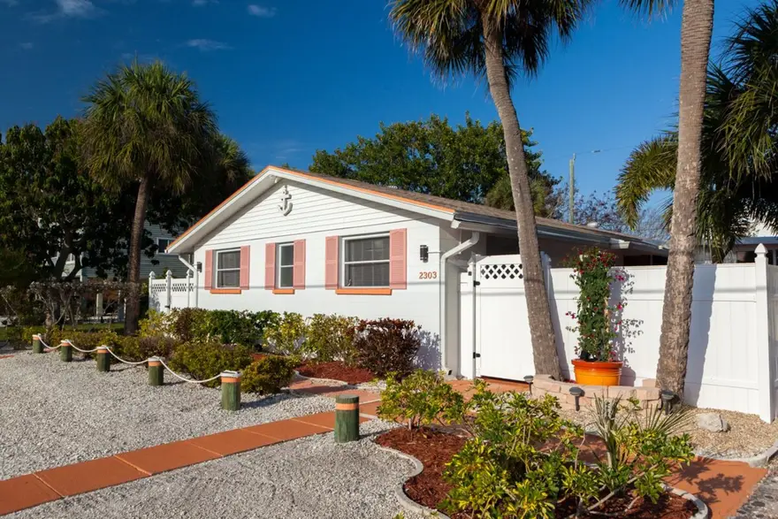 Happy Turtle A: coral-shuttered beach duplex behind a white fence, Bradenton Beach, Anna Maria Island