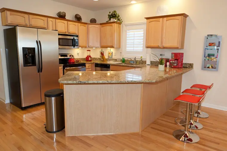 Kitchen with granite island, stainless appliances, and bar stools, Happy Island Cottage