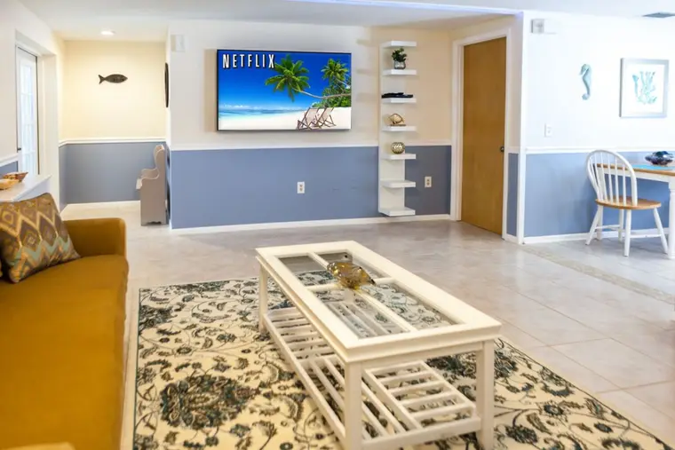 Living room with wall-mounted TV and coastal blue wainscoting, Happy Turtle A