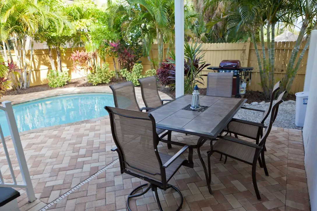 Covered patio with dining table and grill beside the private pool, Happy Island Cottage